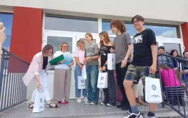 Uczniowie, wraz z nauczycielką, odbierają nagrody