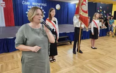 Przem&oacute;wienie pani dyrektor na tle pocztu sztandarowego szkoły