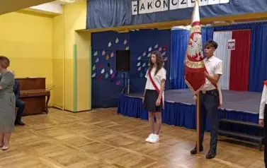 Przem&oacute;wienie pani dyrektor na tle pocztu sztandarowego szkoły