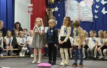 Uczniowie klas pierwszych na scenie recytują wiersz