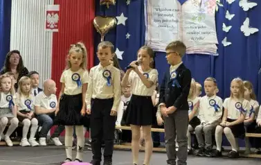 Uczniowie klas pierwszych na scenie recytują wiersz