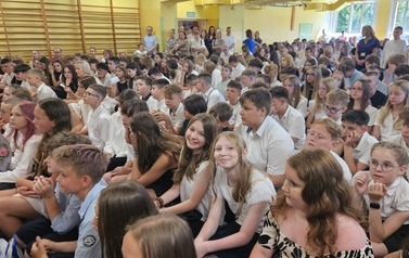 Uczniowie klas 4-7 siedzą na ławkach