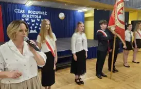 Przem&oacute;wienie pani dyrektor na tle pocztu sztandarowego szkoły