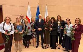 Wyr&oacute;żnione osoby pozują z medalami i kwiatami