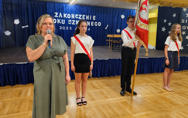 Pani Dyrektor przemawia na tle pocztu sztandarowego