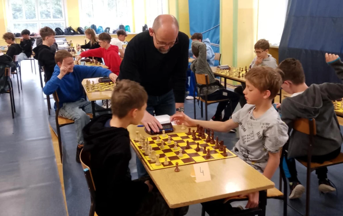 Duża grupa uczniów gra w szachy