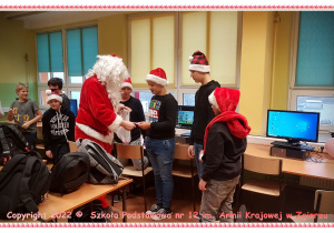 Mikołaj rozdaje słodkości uczniom w klasie