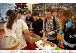 Uczniowie klasy 6c sprzedają swoje produkty podczas kiermaszu.