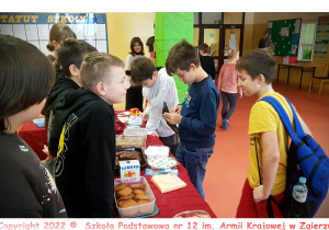 Uczniowie klasy 6c sprzedają swoje produkty podczas kiermaszu.